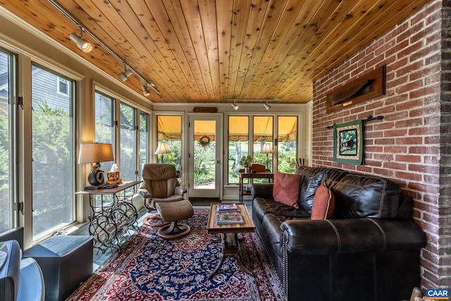 sunroom / solarium featuring a healthy amount of sunlight, wood ceiling, and rail lighting