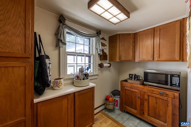 kitchen featuring ornamental molding and light tile patterned flooring