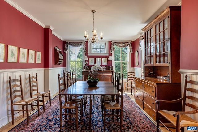 dining room with an inviting chandelier, crown molding, and dark hardwood / wood-style flooring