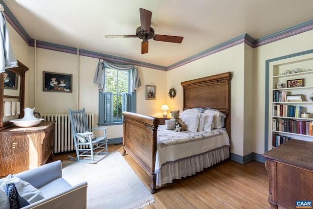 bedroom with crown molding, radiator, light wood-type flooring, and ceiling fan