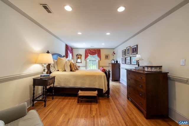 bedroom with ornamental molding and light wood-type flooring