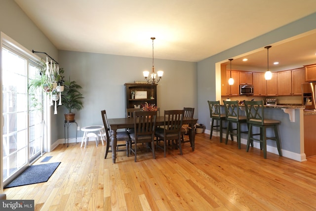 dining area featuring an inviting chandelier and light wood-type flooring