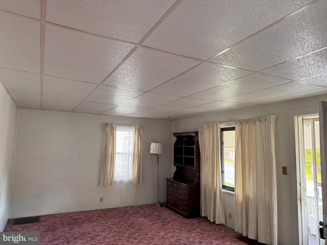 unfurnished room with a paneled ceiling and carpet flooring