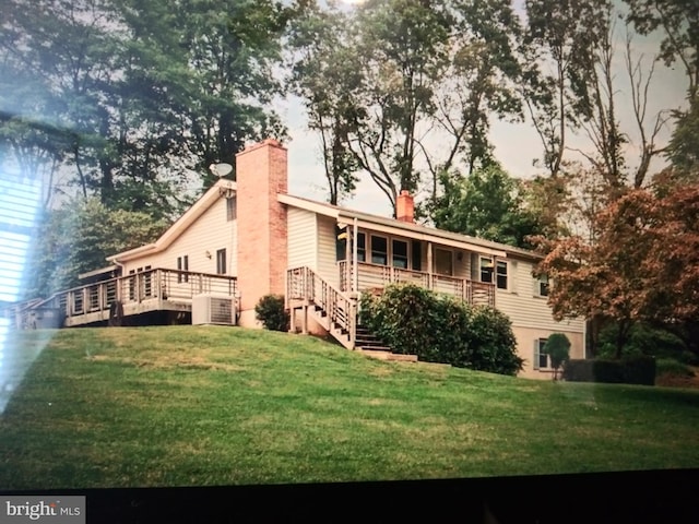 rear view of house featuring a yard and cooling unit