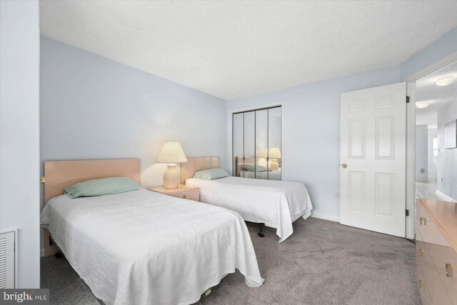 carpeted bedroom with a closet and a textured ceiling