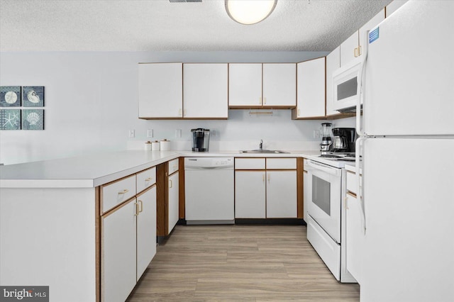 kitchen with sink, white cabinets, a textured ceiling, and white appliances