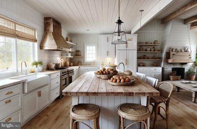 kitchen featuring custom range hood, open shelves, wood counters, a sink, and white cabinets