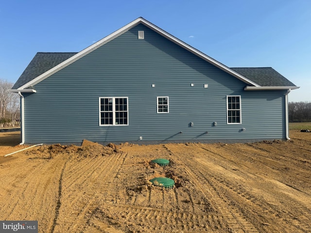 rear view of property featuring a shingled roof