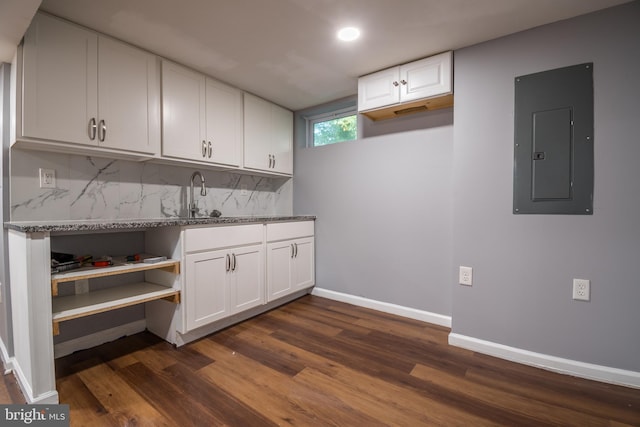 interior space with dark stone countertops, white cabinets, electric panel, and dark hardwood / wood-style floors