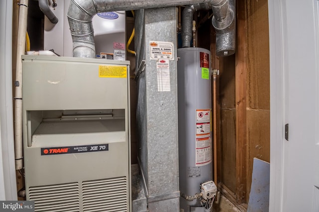 utility room featuring water heater and heating unit