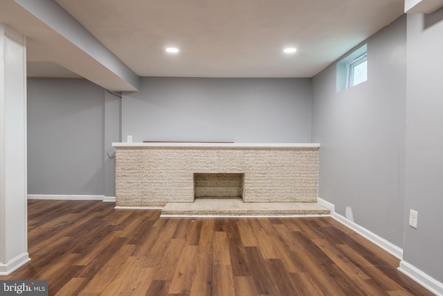 unfurnished living room featuring bar area and dark hardwood / wood-style flooring