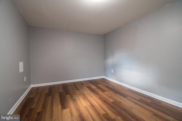 empty room with dark hardwood / wood-style flooring