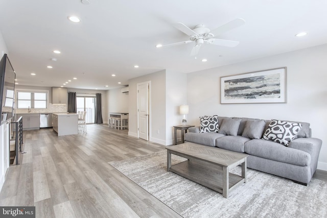 living room with light hardwood / wood-style floors and ceiling fan