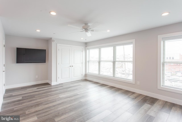 unfurnished living room with ceiling fan and light wood-type flooring