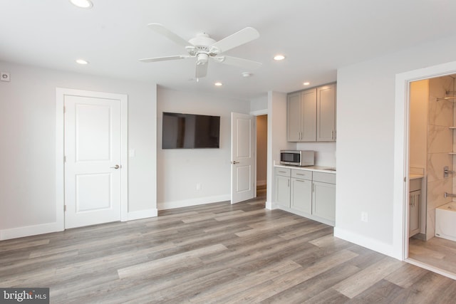 unfurnished living room with light wood-type flooring and ceiling fan