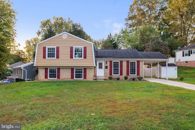 tri-level home featuring a front lawn and a carport