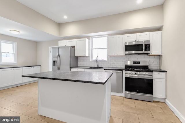 kitchen featuring appliances with stainless steel finishes, sink, a kitchen island, and a wealth of natural light