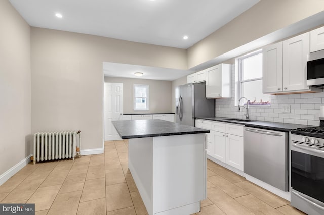 kitchen with plenty of natural light, a center island, stainless steel appliances, and radiator