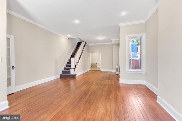 unfurnished living room with crown molding and hardwood / wood-style flooring