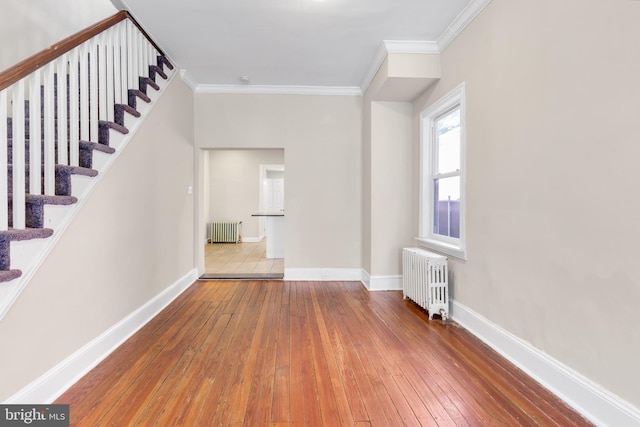 interior space with crown molding, hardwood / wood-style flooring, and radiator heating unit