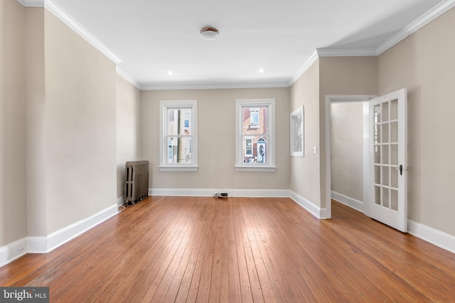 empty room featuring ornamental molding, hardwood / wood-style floors, and radiator