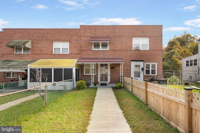 multi unit property with a front yard and a sunroom