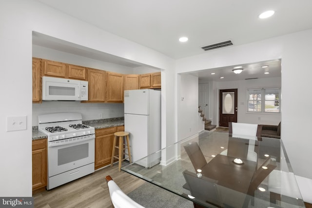 kitchen with light hardwood / wood-style floors and white appliances