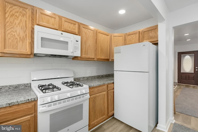 kitchen featuring tasteful backsplash, light wood-type flooring, and white appliances