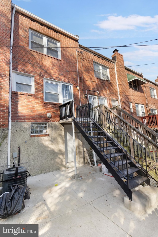 rear view of property with a patio area and cooling unit