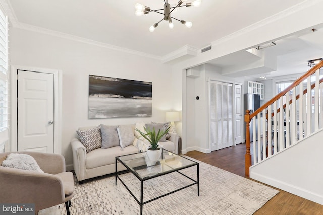 living room featuring crown molding, hardwood / wood-style flooring, and a chandelier