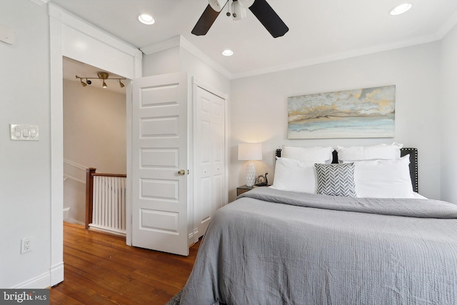 bedroom with a closet, ceiling fan, crown molding, and dark hardwood / wood-style floors