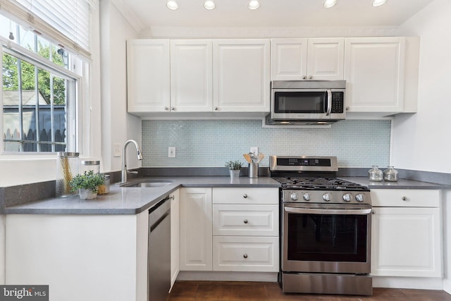 kitchen featuring backsplash, stainless steel appliances, sink, and white cabinets