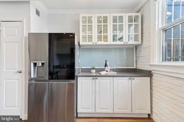 kitchen with ornamental molding, stainless steel fridge, white cabinetry, and light hardwood / wood-style flooring