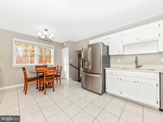 kitchen with white cabinetry, sink, stainless steel fridge with ice dispenser, a chandelier, and light tile patterned floors