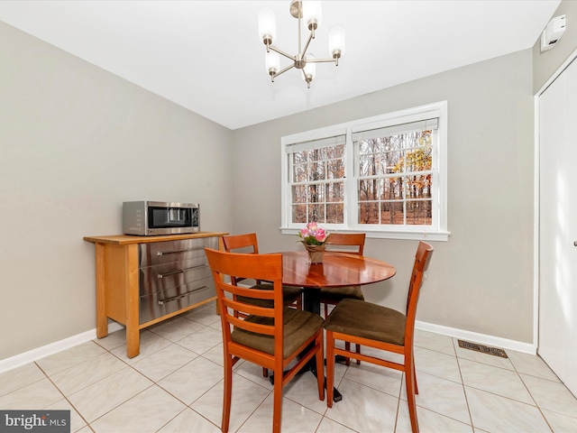 dining space with an inviting chandelier and light tile patterned flooring