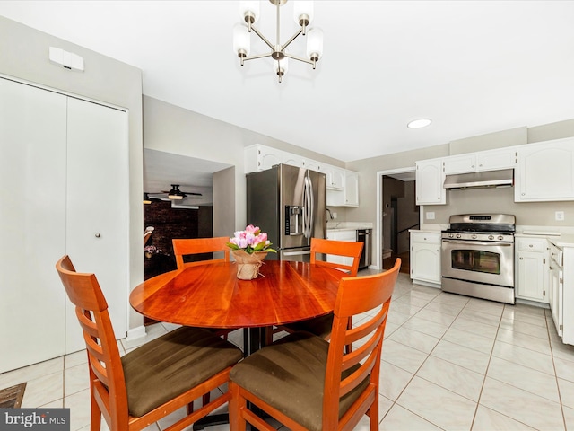 tiled dining room with ceiling fan with notable chandelier