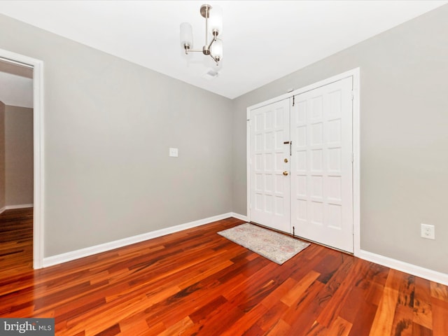 entrance foyer with a notable chandelier and wood-type flooring