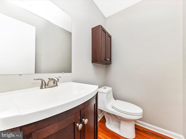 bathroom with hardwood / wood-style floors, vanity, and toilet