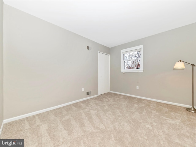 unfurnished room featuring light carpet