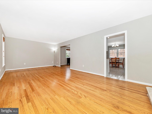 unfurnished room featuring light hardwood / wood-style flooring and a notable chandelier