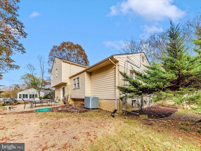 rear view of house featuring cooling unit and a patio