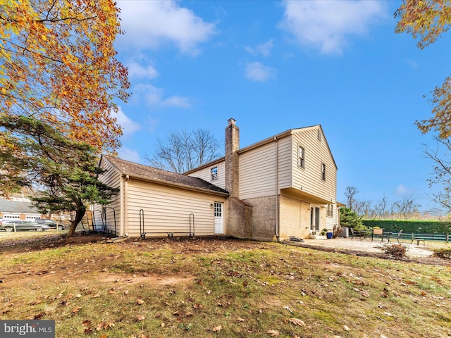 back of property with a lawn and a patio area