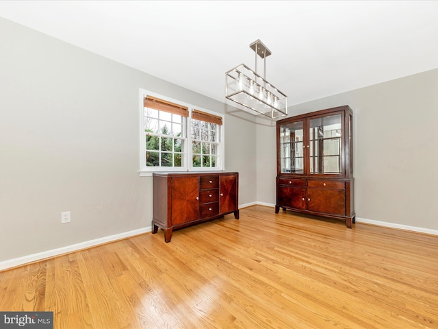 dining area featuring light hardwood / wood-style flooring and an inviting chandelier