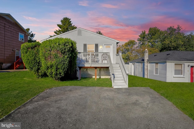 view of front of house featuring a wooden deck and a lawn