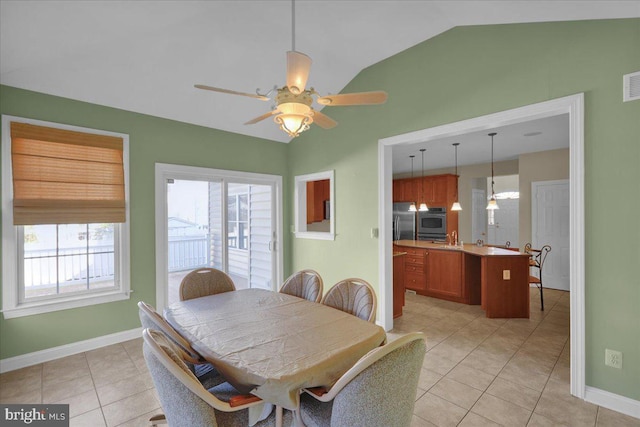 tiled dining room featuring ceiling fan and vaulted ceiling