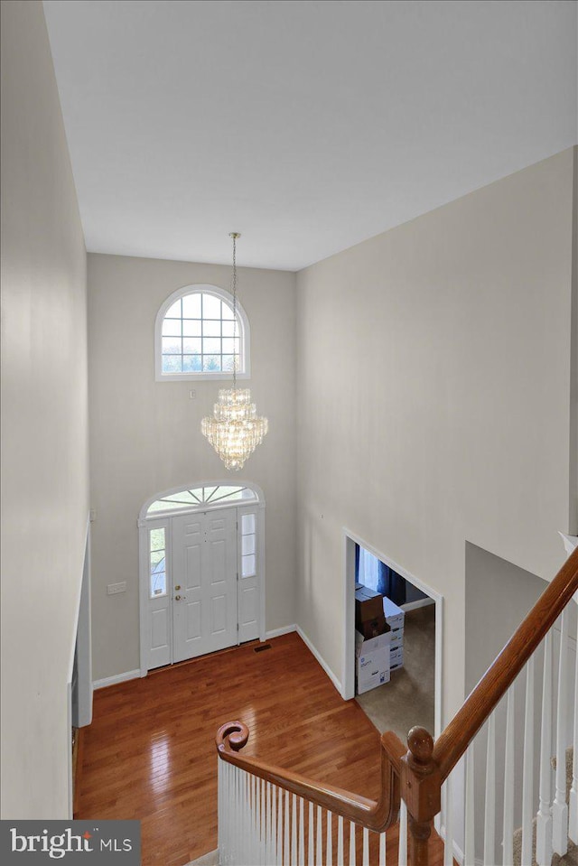 foyer with a chandelier and wood-type flooring