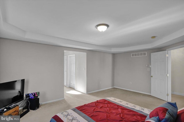 carpeted bedroom featuring a tray ceiling