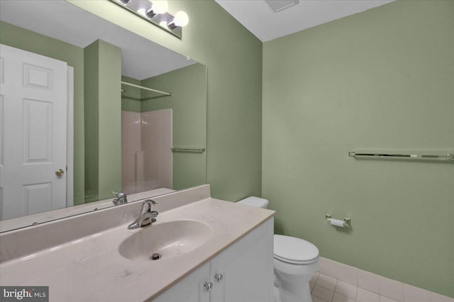 bathroom featuring vanity, a shower, toilet, and tile patterned flooring