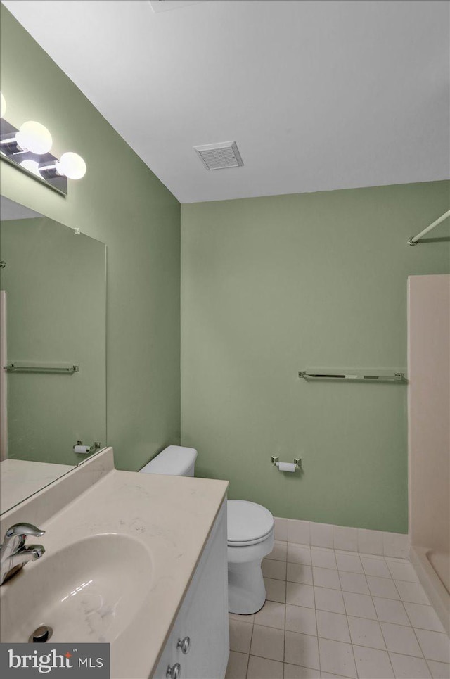 bathroom featuring vanity, tile patterned floors, a shower, and toilet