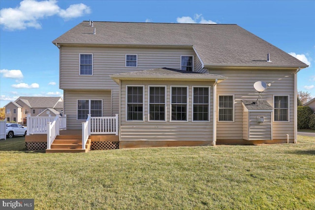 rear view of house featuring a wooden deck and a yard